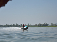 Omar Abdullah, leader of the National Conference, a regional political party, rides a jet ski during a boat rally ahead of the second phase...