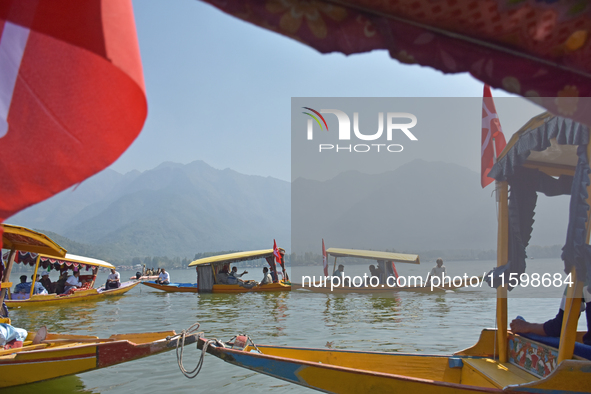 Supporters of the National Conference, a regional political party, hold a boat rally ahead of the second phase of assembly elections in Dal...