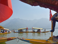 Supporters of the National Conference, a regional political party, hold a boat rally ahead of the second phase of assembly elections in Dal...