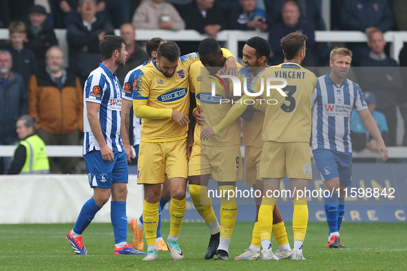 Josh Umerah of Dagenham & Redbridge celebrates with his teammates after scoring their first goal during the Vanarama National League match b...