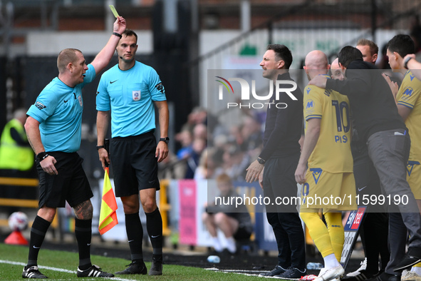 Referee Lee Swabey shows a yellow card to Stuart Maynard, manager of Notts County, during the Sky Bet League 2 match between Notts County an...