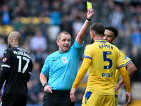 Referee Lee Swabey shows a yellow card to Max Ehmer of Gillingham during the Sky Bet League 2 match between Notts County and Gillingham at M...