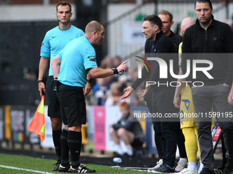 Referee Lee Swabey speaks with Stuart Maynard, manager of Notts County, during the Sky Bet League 2 match between Notts County and Gillingha...