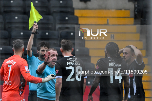 Referee Lee Swabey gestures after County players approach the assistant referee following a lengthy delay showing the offside flag during th...