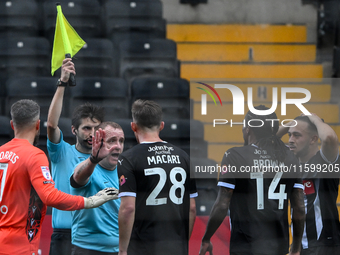 Referee Lee Swabey gestures after County players approach the assistant referee following a lengthy delay showing the offside flag during th...