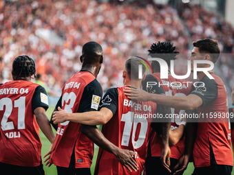 Florian Wirtz of Bayer 04 Leverkusen celebrates his goal with teammates during the Bundesliga match between Bayer 04 Leverkusen and VfL Wolf...