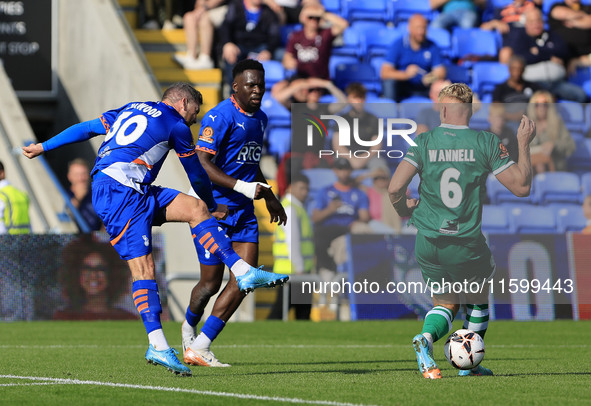 James Norwood of Oldham Athletic Association Football Club has a shot blocked by Jake Wannell of Yeovil Town Football Club during the Vanara...