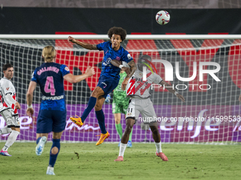 Axel Witsel of Atletico de Madrid (L) in action against Randy Nteka of Rayo Vallecano (R) during the La Liga EA Sports 2024/25 football matc...