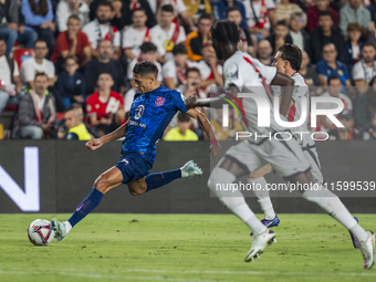 Nahuel Molina of Atletico de Madrid (L) in action with the ball during the La Liga EA Sports 2024/25 football match between Rayo Vallecano a...