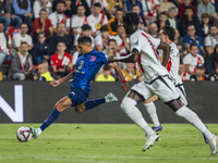 Nahuel Molina of Atletico de Madrid (L) in action with the ball during the La Liga EA Sports 2024/25 football match between Rayo Vallecano a...