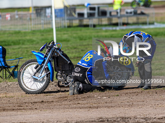 Kenny Van Eeckhout of Belgium tries to refit the chain on his machine in the Sidecar Support Class during the FIM Long Track World Champions...