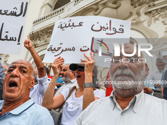 A female demonstrator shouts slogans as she raises a placard that reads in Arabic, ''absurd laws, theatrics elections,'' during a demonstrat...