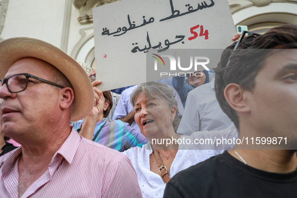 An elderly female demonstrator shouts slogans as she raises a placard that reads, ''Down with the regime of July 54,'' during a demonstratio...