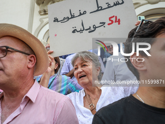 An elderly female demonstrator shouts slogans as she raises a placard that reads, ''Down with the regime of July 54,'' during a demonstratio...