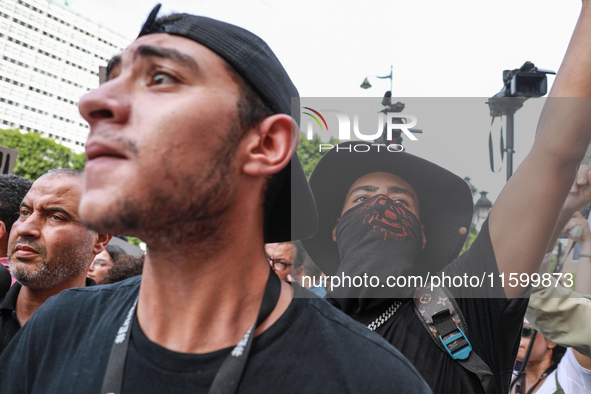 A young demonstrator with his face covered by a bandanna waves his arm during a demonstration organized by the Tunisian Network for Rights a...