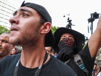 A young demonstrator with his face covered by a bandanna waves his arm during a demonstration organized by the Tunisian Network for Rights a...