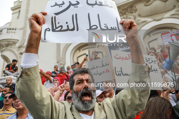 A demonstrator raises a placard that reads in Arabic, ''The people want to bring down the regime,'' during a demonstration organized by the...