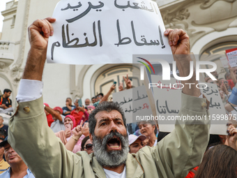 A demonstrator raises a placard that reads in Arabic, ''The people want to bring down the regime,'' during a demonstration organized by the...