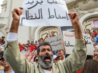 A demonstrator raises a placard that reads in Arabic, ''The people want to bring down the regime,'' during a demonstration organized by the...