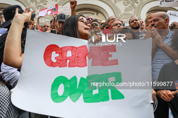 A female demonstrator shouts slogans as she holds a placard that reads ''Game Over'' during a demonstration organized by the Tunisian Networ...