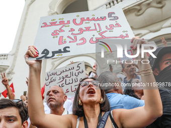 A female demonstrator shouts slogans as she raises a placard that reads in Arabic, ''He does nothing for five years,'' during a demonstratio...