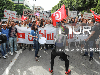 Demonstrators wave national Tunisian flags and raise placards during a demonstration organized by the Tunisian Network for Rights and Freedo...