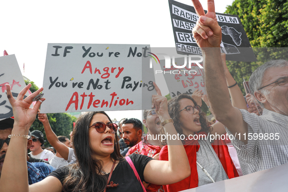 A young female demonstrator shouts slogans as she raises a placard that reads, ''If you are not angry, you are not paying attention,'' durin...