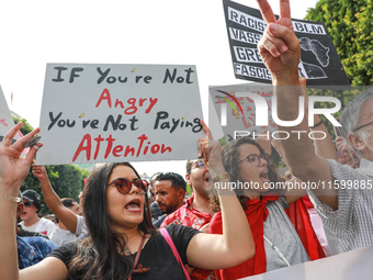 A young female demonstrator shouts slogans as she raises a placard that reads, ''If you are not angry, you are not paying attention,'' durin...