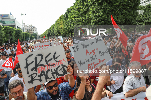 Demonstrators wave national Tunisian flags and raise placards during a demonstration organized by the Tunisian Network for Rights and Freedo...