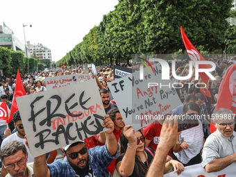 Demonstrators wave national Tunisian flags and raise placards during a demonstration organized by the Tunisian Network for Rights and Freedo...