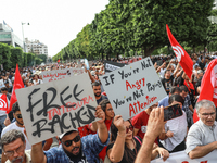 Demonstrators wave national Tunisian flags and raise placards during a demonstration organized by the Tunisian Network for Rights and Freedo...