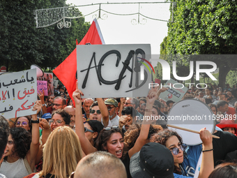 A young woman raises a placard that reads ''ACAB'' during a demonstration organized by the Tunisian Network for Rights and Freedoms in Tunis...