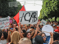 A young woman raises a placard that reads ''ACAB'' during a demonstration organized by the Tunisian Network for Rights and Freedoms in Tunis...