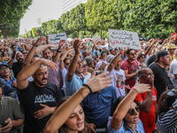 Demonstrators wave their arms as they shout, ''DEGAGE'' (get out), during a demonstration organized by the Tunisian Network for Rights and F...