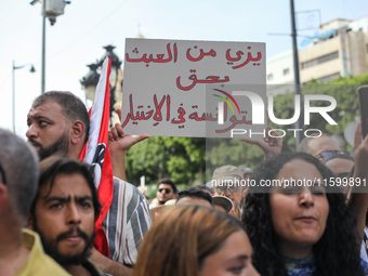 A demonstrator raises a placard that reads in Arabic, ''Stop making a mockery of the Tunisians' right to make their own choice,'' during a d...