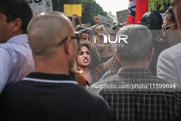 A young female demonstrator raises her fist as she shouts slogans during a demonstration organized by the Tunisian Network for Rights and Fr...