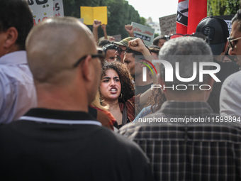 A young female demonstrator raises her fist as she shouts slogans during a demonstration organized by the Tunisian Network for Rights and Fr...