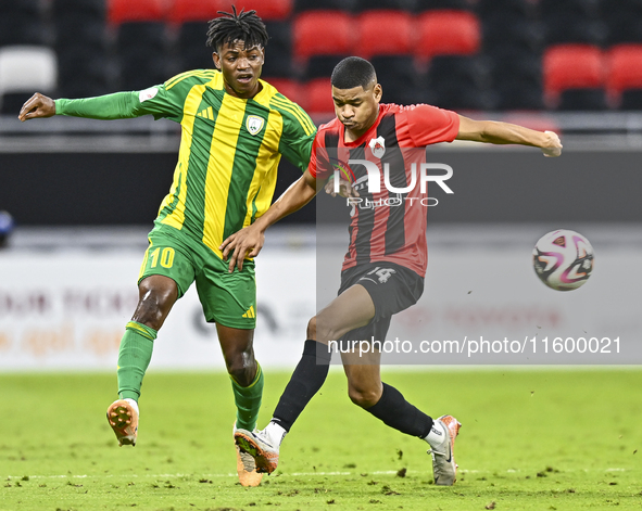 Jacinto Dala (L) of Al Wakrah SC battles for the ball with Andre Adel Bader Al-Ahmad (R) of Al Rayyan SC during the Ooredoo Qatar Stars Leag...