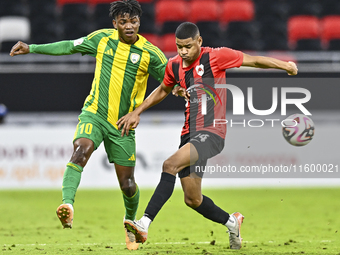 Jacinto Dala (L) of Al Wakrah SC battles for the ball with Andre Adel Bader Al-Ahmad (R) of Al Rayyan SC during the Ooredoo Qatar Stars Leag...