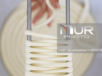 A worker processes hollow hanging noodles at a workshop in Suqian, Jiangsu province, China, on September 22, 2024. (