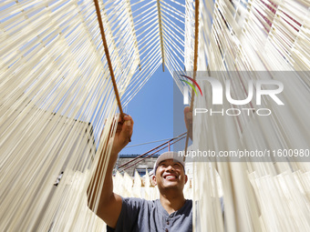 A worker processes hollow hanging noodles at a workshop in Suqian, Jiangsu province, China, on September 22, 2024. (