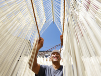 A worker processes hollow hanging noodles at a workshop in Suqian, Jiangsu province, China, on September 22, 2024. (