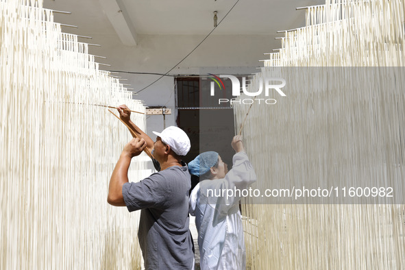 A worker processes hollow hanging noodles at a workshop in Suqian, Jiangsu province, China, on September 22, 2024. 