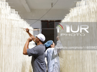 A worker processes hollow hanging noodles at a workshop in Suqian, Jiangsu province, China, on September 22, 2024. (