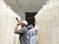 A worker processes hollow hanging noodles at a workshop in Suqian, Jiangsu province, China, on September 22, 2024. (