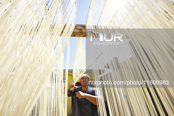 A worker processes hollow hanging noodles at a workshop in Suqian, Jiangsu province, China, on September 22, 2024. 