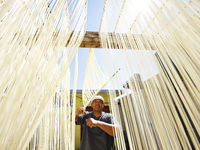 A worker processes hollow hanging noodles at a workshop in Suqian, Jiangsu province, China, on September 22, 2024. (