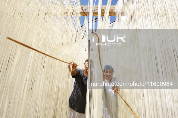 A worker processes hollow hanging noodles at a workshop in Suqian, Jiangsu province, China, on September 22, 2024. 