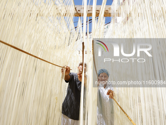 A worker processes hollow hanging noodles at a workshop in Suqian, Jiangsu province, China, on September 22, 2024. (