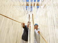 A worker processes hollow hanging noodles at a workshop in Suqian, Jiangsu province, China, on September 22, 2024. (